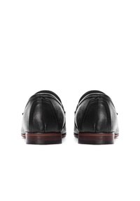 Juodi odiniai loaferiai su lygiu paviršiumi, apvalia nosimi ir mediniu padu. Viršuje nėra matomų detalių ar raštų.