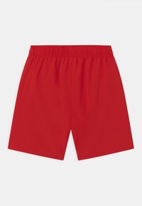 Punaiset shortsit, joissa on joustava vyötärö ja jotka on valmistettu sileästä, kevyestä kankaasta. Ominaisuuksiin kuuluu yksinkertainen, yhtenäinen väri ilman kuvioita tai koristeita.