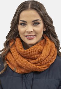 Kötött végtelen sál égett narancsszínben, jellegzetes, vastag textúrával és sima felülettel, egy kis márkajelzéssel az egyik oldalon.