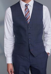 Marineblaue Weste mit dezentem Karomuster, einreiheriges Design, fünf Knöpfe und zwei Taschen; kombiniert mit einem weißen Hemd und einer gestreiften Krawatte.