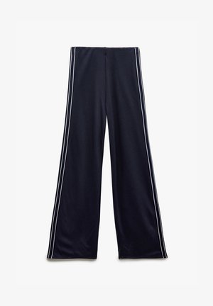 Pantalons larges bleu marine en tissu doux, dotés de deux bandes blanches sur les côtés, d'une taille haute et d'une texture lisse.