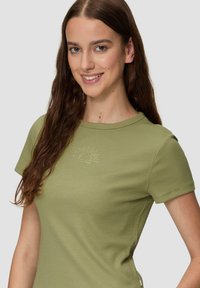 Olijfgroen geribbeld t-shirt met korte mouwen, een ronde halslijn en een zonpatroon van versieringen op het borstgedeelte.