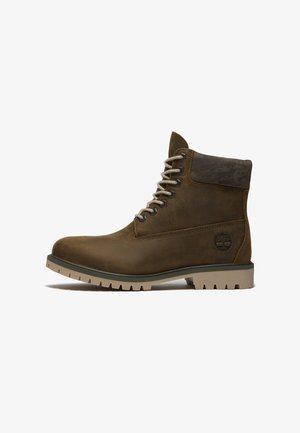 Bottine marron en cuir à lacets avec col rembourré, semelle robuste et logo embossé sur le côté, conçue pour une utilisation extérieure.