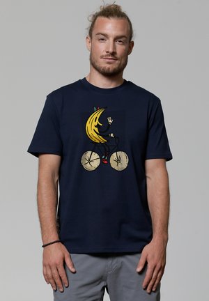 Navyblaue Baumwoll-T-Shirt mit einer Grafik eines Bananencharakters, der Fahrrad fährt, mit gelben und roten Akzenten und einem verspielten Design.
