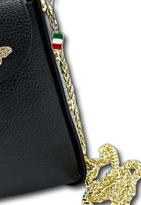 Zwarte handtas met textuur, voorzien van een gouden kettinghengsel en een klein Italiaanse vlag charm dat aan de bovenhoek is bevestigd.