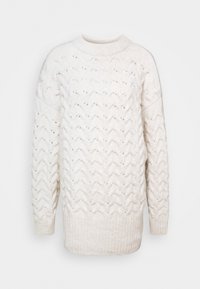 Maglione lavorato a maglia di colore crema con un motivo a zigzag testurizzato, orlo a coste e collo rotondo. Realizzato in materiale morbido e caldo. Vestibilità ampia.