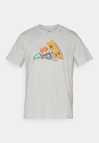 Grå T-skjorte med kort erm som har et fargerikt tegneserie-design med en skateboarder og skrå bygninger. Laget av bomull med en myk tekstur.