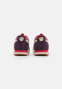 Scarpe sportive in suede viola con dettagli rosa, suola bianca e logo dorato sul tallone. Progettate per comfort e supporto.