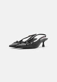 Svarta lackläder slingback-hälar med spetsiga tår, små kittenklackar och dekorativa rosetter fram. Slät textur och elegant design.