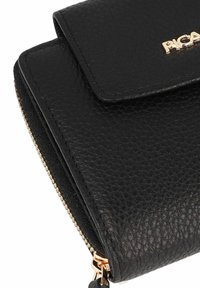La cartera de piel negra presenta una superficie texturizada, un logo dorado y un cierre con cremallera con un tirador dorado.