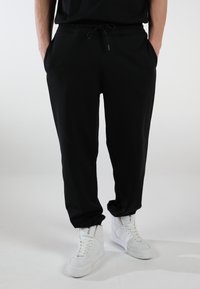 ELEVATE - Tracksuit bottoms - inky black