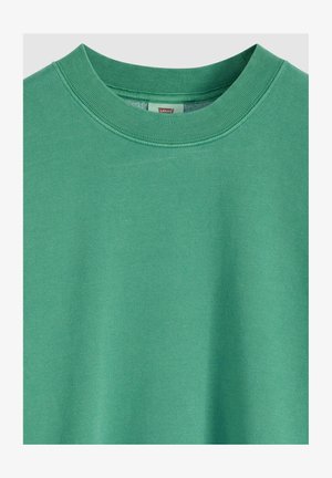 Vihreä puuvillainen collegepaita, jossa on pyöreä kaula-aukko, resorireunus ja sileä pinta, painottaen yksinkertaisuutta ja mukavuutta.