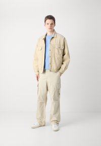 Tommy Jeans AIDEN BAGGY - Cargo trousers - beige