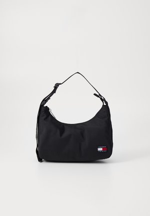 Sort skuldertaske med justerbar rem og lille Tommy Jeans logo på forsiden mod en ensfarvet hvid baggrund.