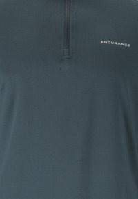 Dunkelblaues Sportshirt mit einem Viertelreisverschluss und einer glatten Textur. Verfügt über das "ENDURANCE"-Logo im Bereich der rechten Brust.