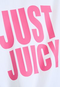 T-shirt in tessuto bianco con grande scritta in rosa audace che recita "JUST JUICY." Texture liscia con un contrasto di colori vivaci.