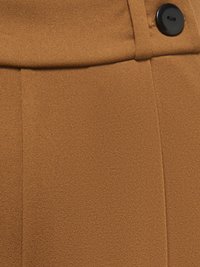 Gros plan d'un tissu marron texturé avec un bouton noir cousu près d'une couture horizontale et des lignes de points verticales.