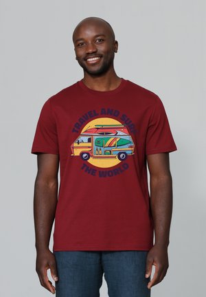 Bordeaux katoenen t-shirt met korte mouwen, voorzien van een grote afbeelding van een kleurrijke bus en surfplanken, met de tekst "REIS EN SURF DE WERELD".