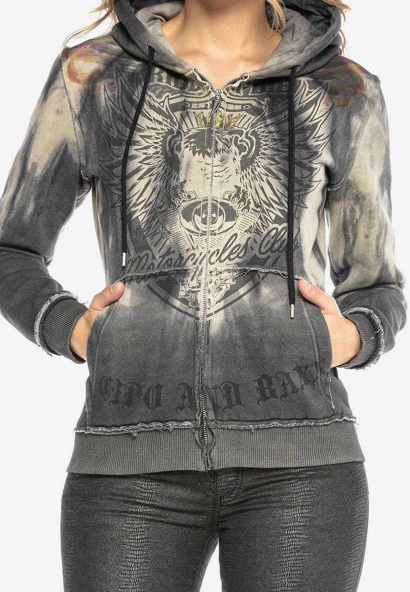 Grijze zip-up hoodie met een verweerde afwerking, grafisch ontwerp van een adelaar en tekst, met voorkanten zakken en een capuchon met trekkoord.