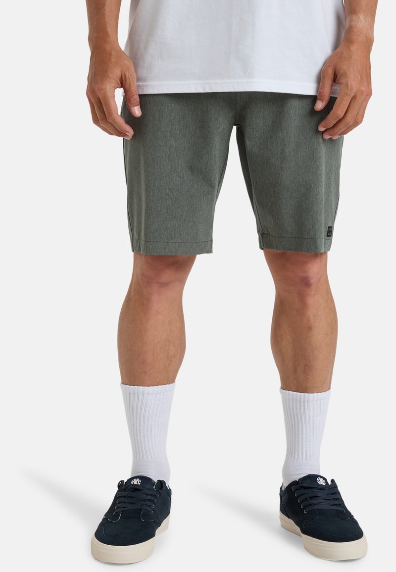 Pantaloni corti da uomo in verde melange realizzati in tessuto testurizzato, con vestibilità standard, tasche laterali e un piccolo logo nero sull'orlo.