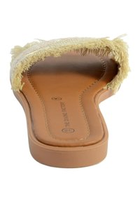 Tan instap sandaal met een bruine leren binnenzool en een rafelige beige bovenkant. Eenvoudig ontwerp met open teen en platte zool.