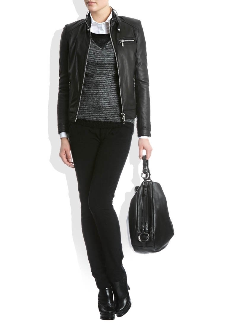 Veste en cuir noir avec quincaillerie argentée, pull en laine gris et pantalon noir. Le modèle tient un sac en cuir noir avec un détail en boucle.