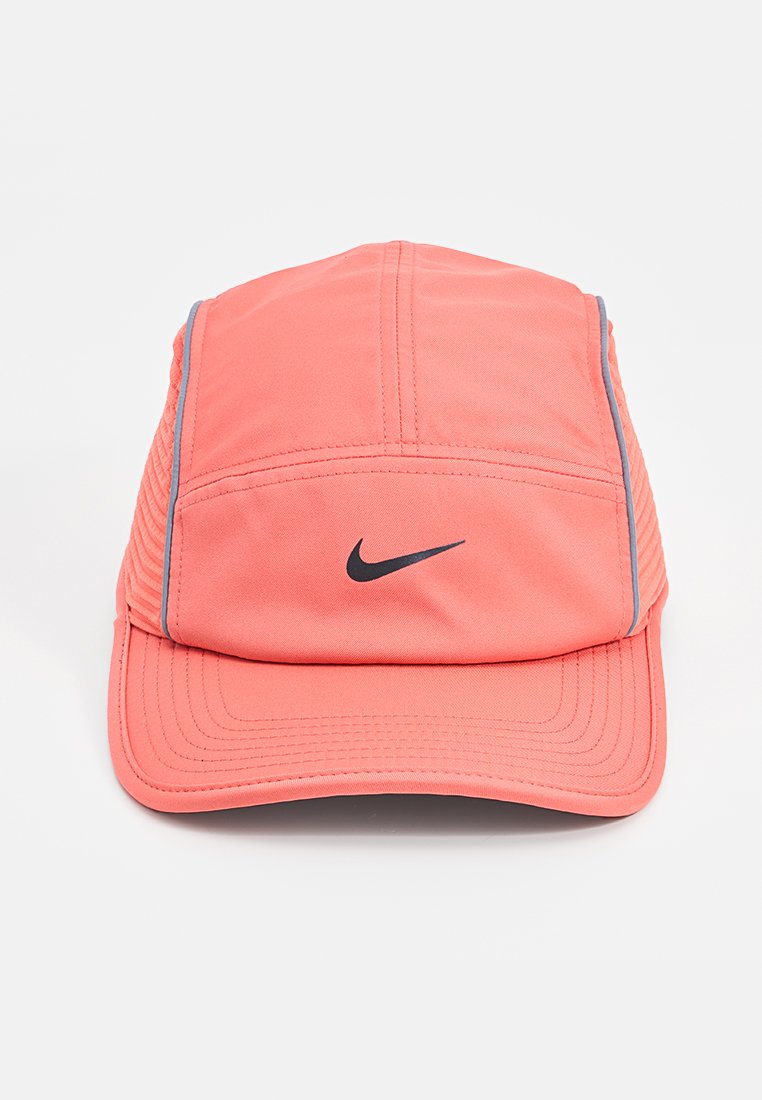 Casquette de sport Nike rose corail avec logo swoosh noir sur le devant et un piping réfléchissant gris sur les côtés.
