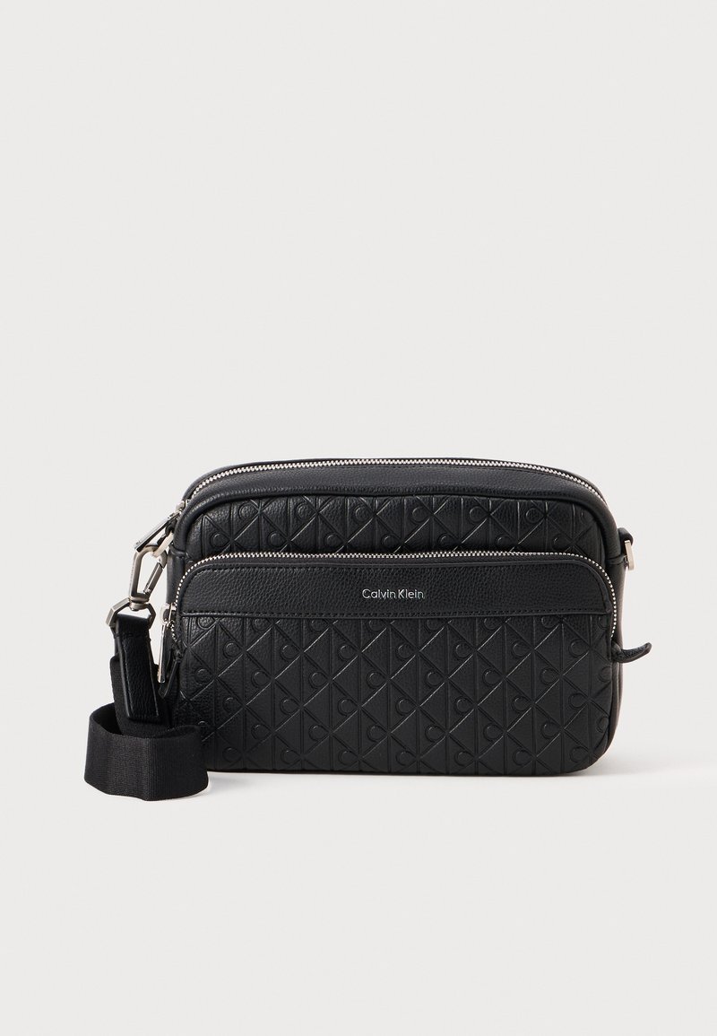 Borsa a tracolla in pelle nera con texture trapuntata, dotata di chiusura con zip e tracolla regolabile. Logo stampato sul pannello anteriore.