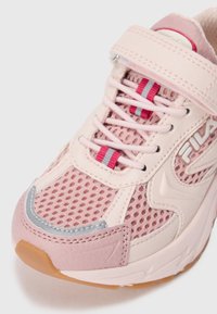 Sneaker Fila rosa e beige con tomaia in mesh, lacci elastici, cinturino in Velcro, dettagli riflettenti e suola in gomma marrone.