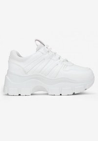 Zapatillas deportivas blancas con una suela gruesa, parte superior sintética, acentos texturizados y una lengüeta acolchada. Presenta múltiples líneas elevadas en los lados.