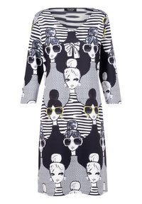 Zwart-witte jurk met herhaalde grafische gezichten van vrouwen die een zonnebril dragen en verschillende kapsels hebben, sommigen met grote strikken, in gestreepte en gestippelde patronen.