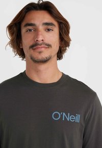 Czarna szaro długa koszulka z rękawem, z okrągłym dekoltem i niebieskim logo "O'Neill" po lewej stronie, wykonana z miękkiego materiału bawełnianego.