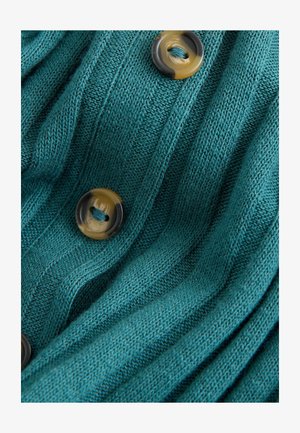 Türkiser Strickcardigan mit gerippter Textur, ausgestattet mit großen runden braunen Knöpfen in verschiedenen Farbtönen, die einen visuellen Kontrast und Details schaffen.