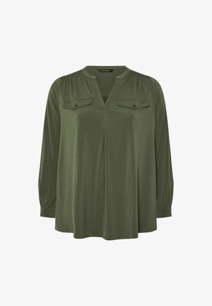 Oliivivihreä paita, jossa on V-pääntie, pitkät hihat ja pleattiliikkeet. Kahdessa rintataskussa on napitus. Sujuva pinta.