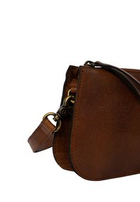 Sac à main en cuir marron avec une texture lisse, une forme arrondie et une bandoulière amovible. Comprend un fermoir en métal et des détails de surpiqûre contrastés.