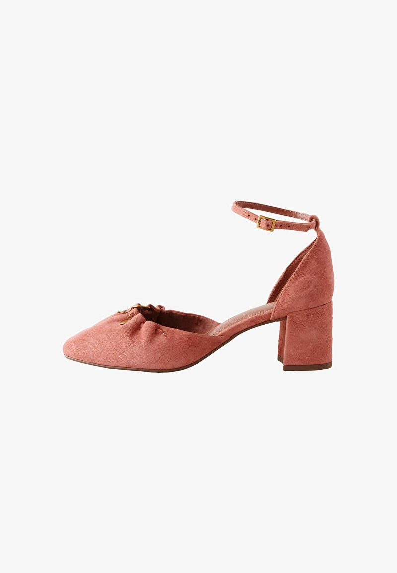 Chaussure femme à talon bloc en daim rose avec bride cheville et bout pointu, dotée d'une petite boucle dorée et de détails froncés à l'avant.