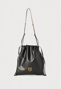 Black leather drawstring bag with a soft texture, gold logo detail, and long adjustable straps. Rounded shape, minimalistic design.