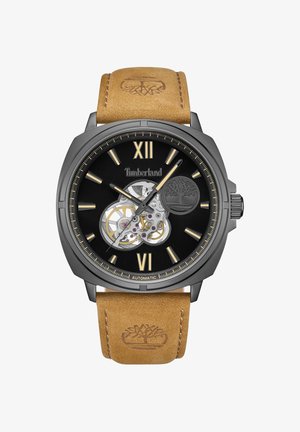 Zwarte automatische horloge met gouden uurmarkeringen, transparante skeletwijzerplaat en bruine leren band met reliëf van het logo.