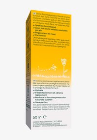 Feuchtigkeitsspendende Creme-Box in Gelb mit weißem Text und Illustrationen. Enthält Produktdetails auf Deutsch und Französisch. Größe: 50 ml.