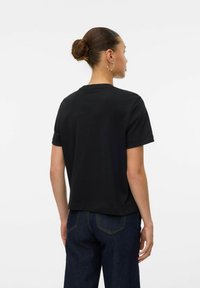Zwarte, T-shirt met korte mouwen en ronde hals, gemaakt van zachte stof; heeft een relaxte pasvorm en een gladde, effen textuur. Achteraanzicht weergegeven.