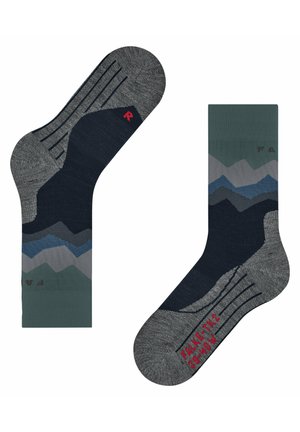 Calcetines grises con patrones de montañas en tonos azul marino, verde y azul. Presentan un borde acanalado y un acento de logo rojo. Material de punto cómodo.