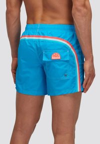 Shorts da bagno blu con cintura elastica, caratterizzati da strisce laterali rosse e bianche e una patch decorativa arancione sulla tasca posteriore.