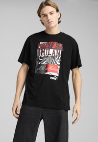 Sort bomulds t-shirt med stort grafisk print med "Forza Milan" og klublogo. Korte ærmer og afslappet pasform. Puma branding nederst.