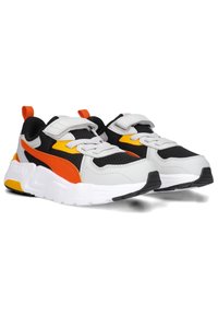Scarpe sportive con un design bianco, nero e arancione, realizzate in materiali mesh e sintetici, con cinturini regolabili e suole texturizzate.