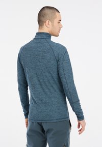 Pullover in pile blu da uomo con colletto alto, maniche lunghe e un motivo testurizzato. Tessuto liscio e leggero, adatto per essere indossato a strati.