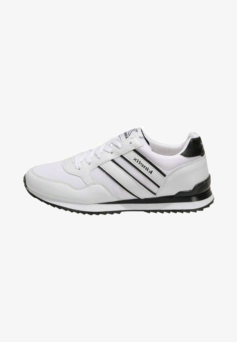 Baskets blanches de sport avec des bandes noires, un talon noir, des lacets blancs et une semelle texturée sur fond blanc.