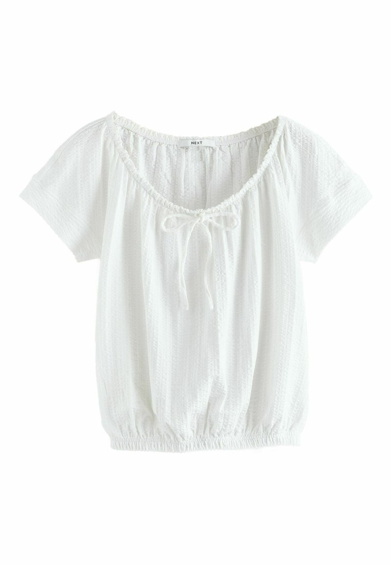 Blouse blanche à manches courtes avec ourlet élastique, encolure ronde, détail noué au centre et fines rayures verticales texturées.