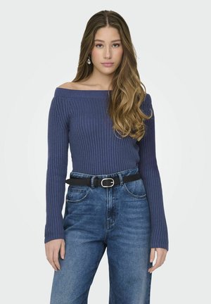 Maglione a coste blu navy con spalle scoperte e maniche lunghe, abbinato a jeans in denim blu chiaro a vita alta e una cintura nera.