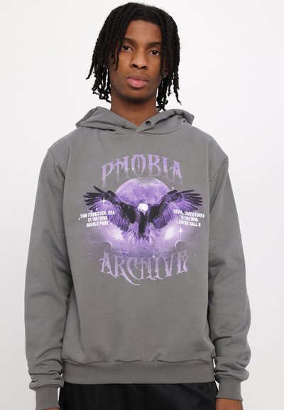 Felpa con cappuccio grigia che presenta una grafica audace in viola con un'aquila e la luna. Tessuto morbido, vestibilità ampia e polsini e orlo a costine.