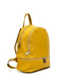 Sac à dos en cuir jaune avec deux compartiments zippés, forme arrondie, finition texturée et bretelles réglables.